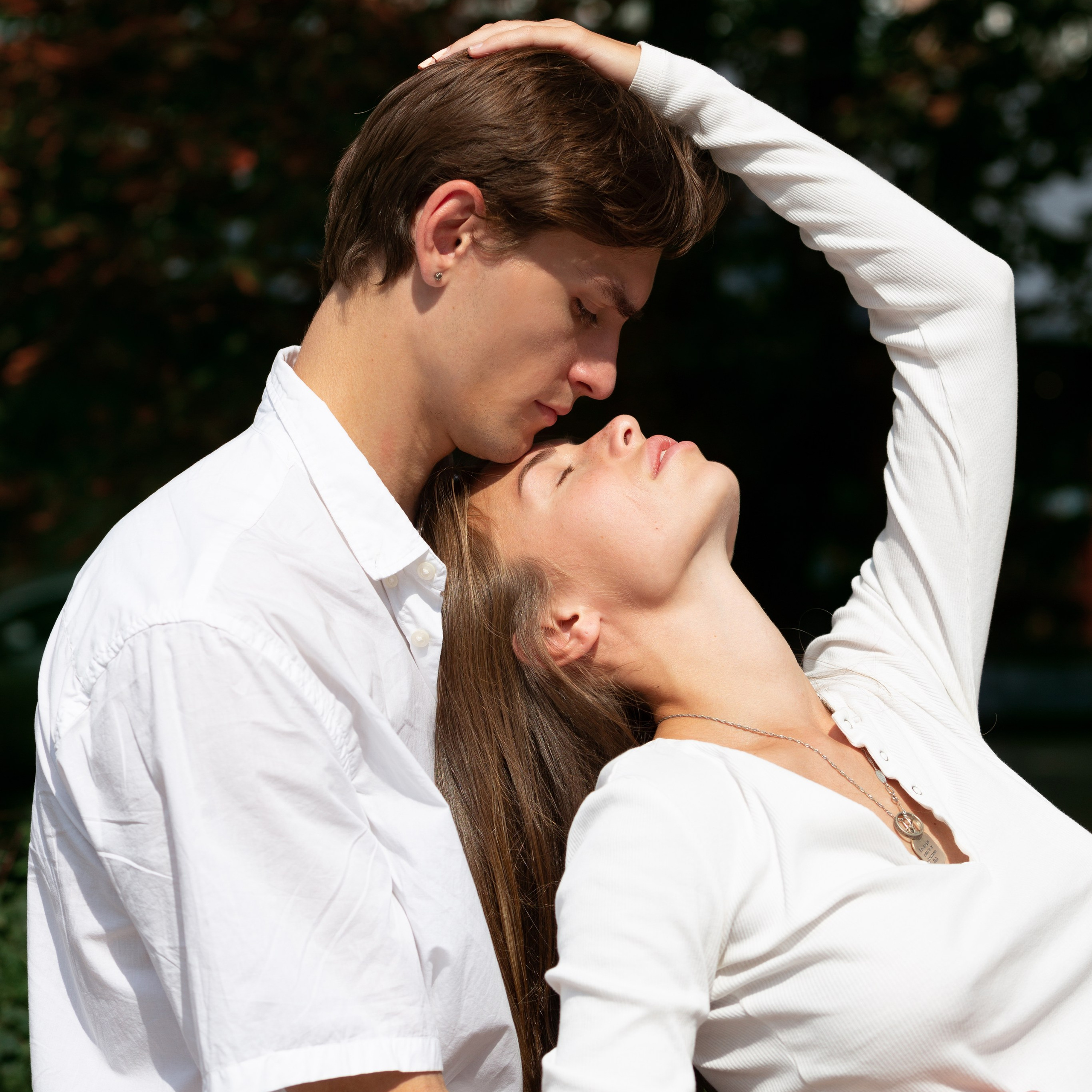 Молодая пара обнимается, сидя на улице. Память о чувствах через бумажные фотографии.