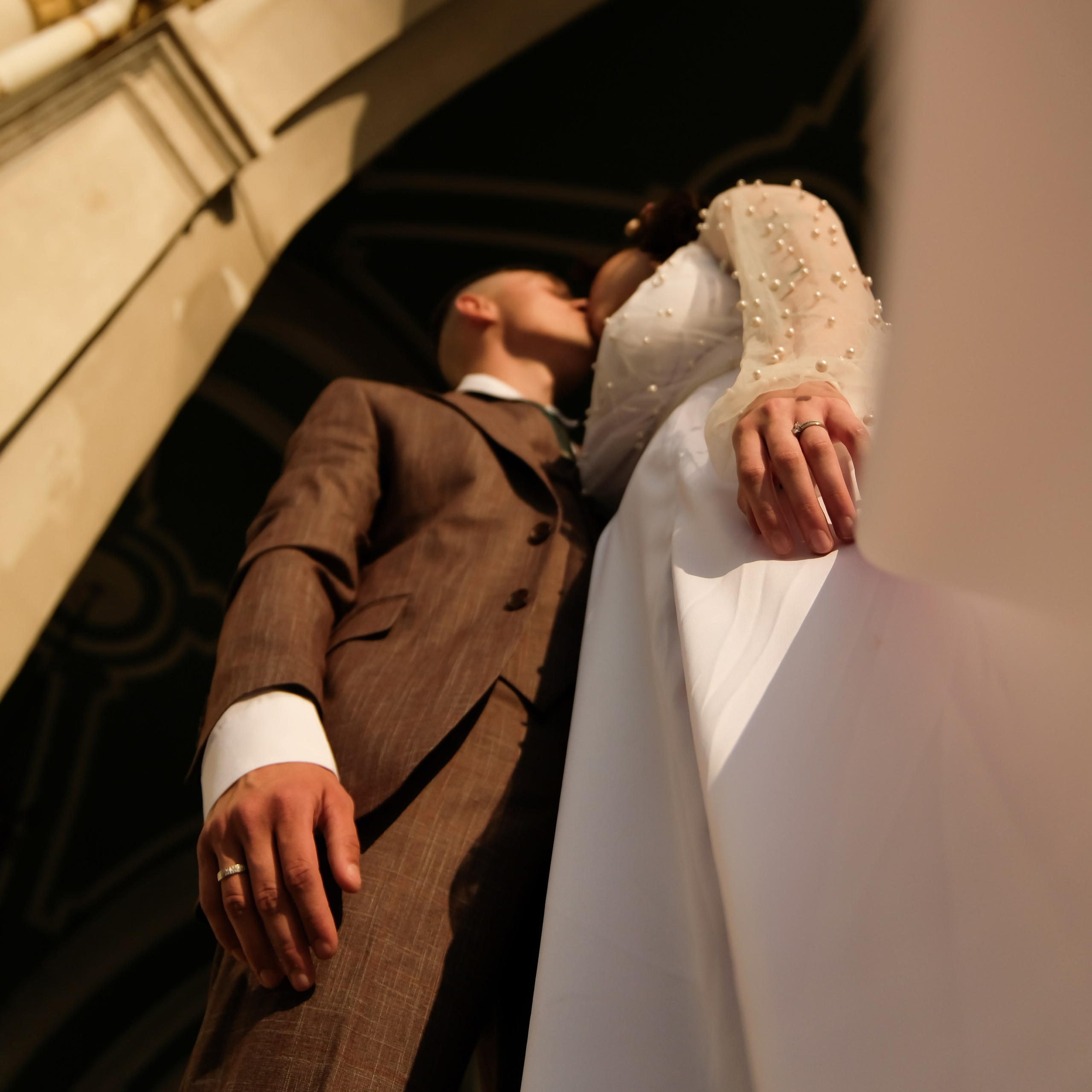 Пара молодожен целуются на закате в архитектуре Петербурга