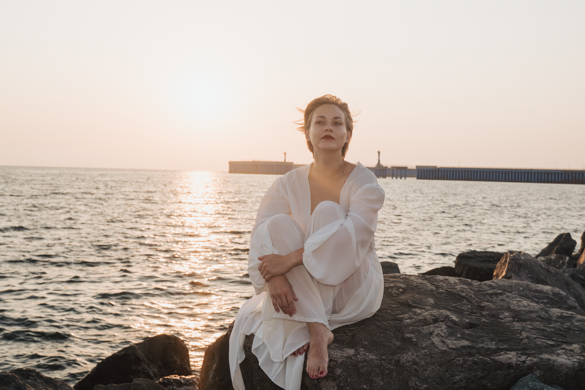 Фотоснимок девушки на закате на камнях