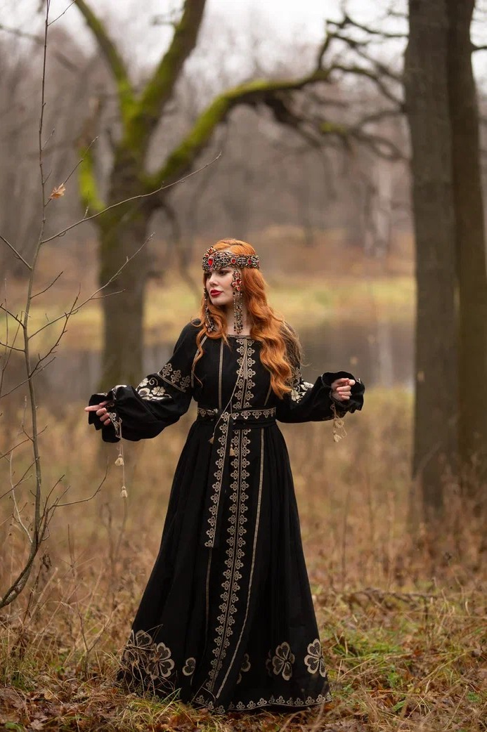 Женщина в образе богини Макошь в черном славянском платье с вышивкой, лесной пейзаж. Славянская фотосессия в стиле Макоши — женская энергия, природа, древний лес. Девушка в этническом наряде с обережной вышивкой, вдохновлённая образом Макоши. Образ богини земли и судьбы — фотосессия в русском стиле в лесу. Макошь — славянская богиня женской силы, в чёрном платье с символикой. Этно-фотосессия в Нижнем Новгороде в стиле славянской богини Макошь. 