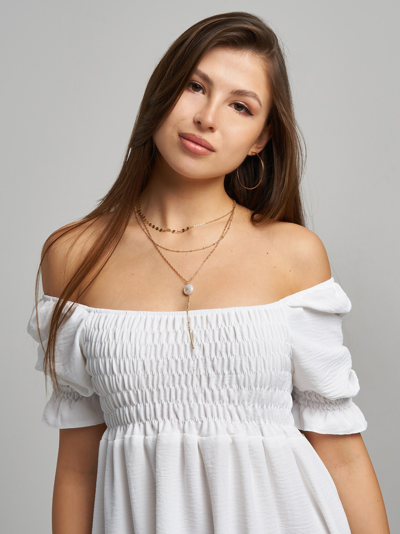 Модель девушка в белом платье на сером фоне