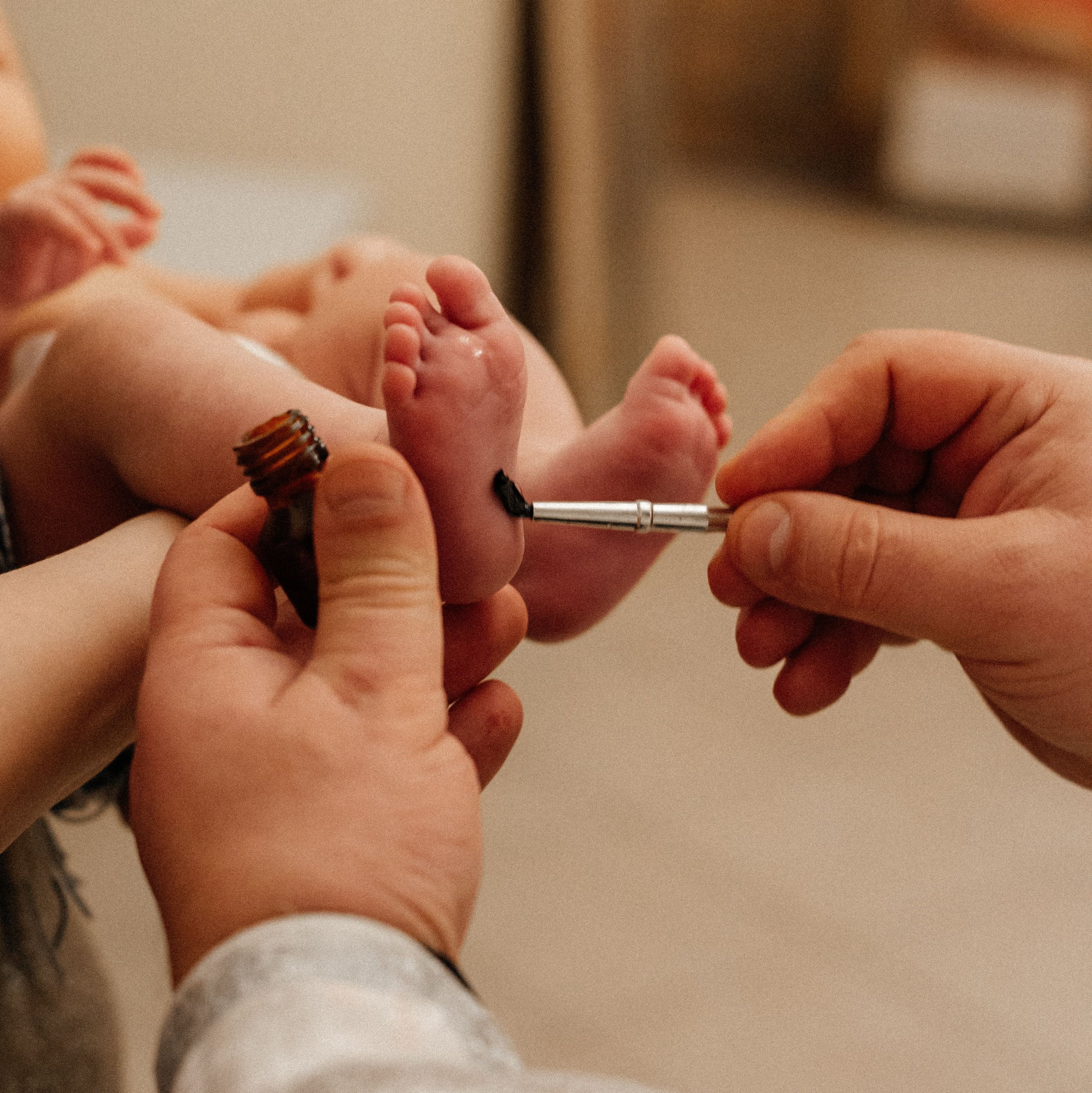 священник помазывает миром стопы ребенку - фотосессия таинства крещения в Москве
