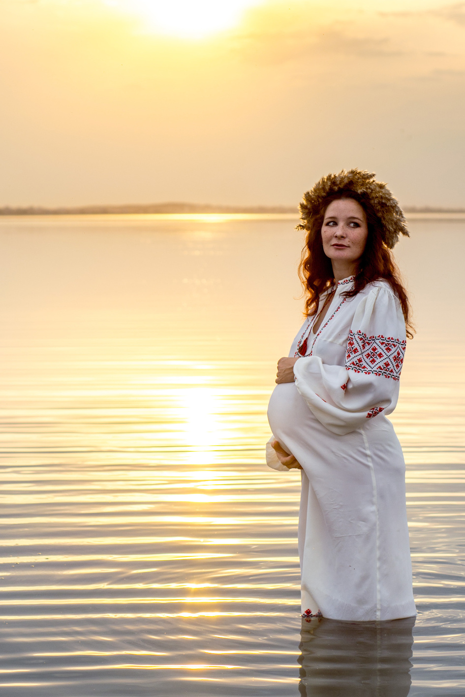 Беременная красавица на закате в озере