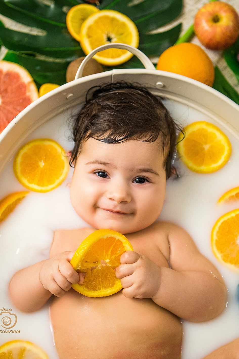 малыш купается в молочной ванне с фруктами