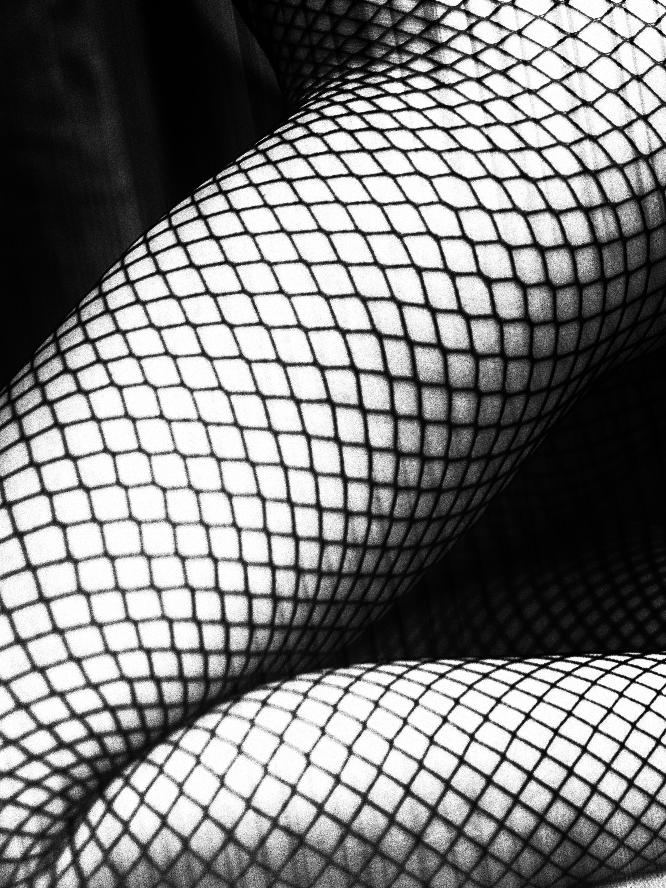 Девичья ножка в чулках из сетки крупным планом.