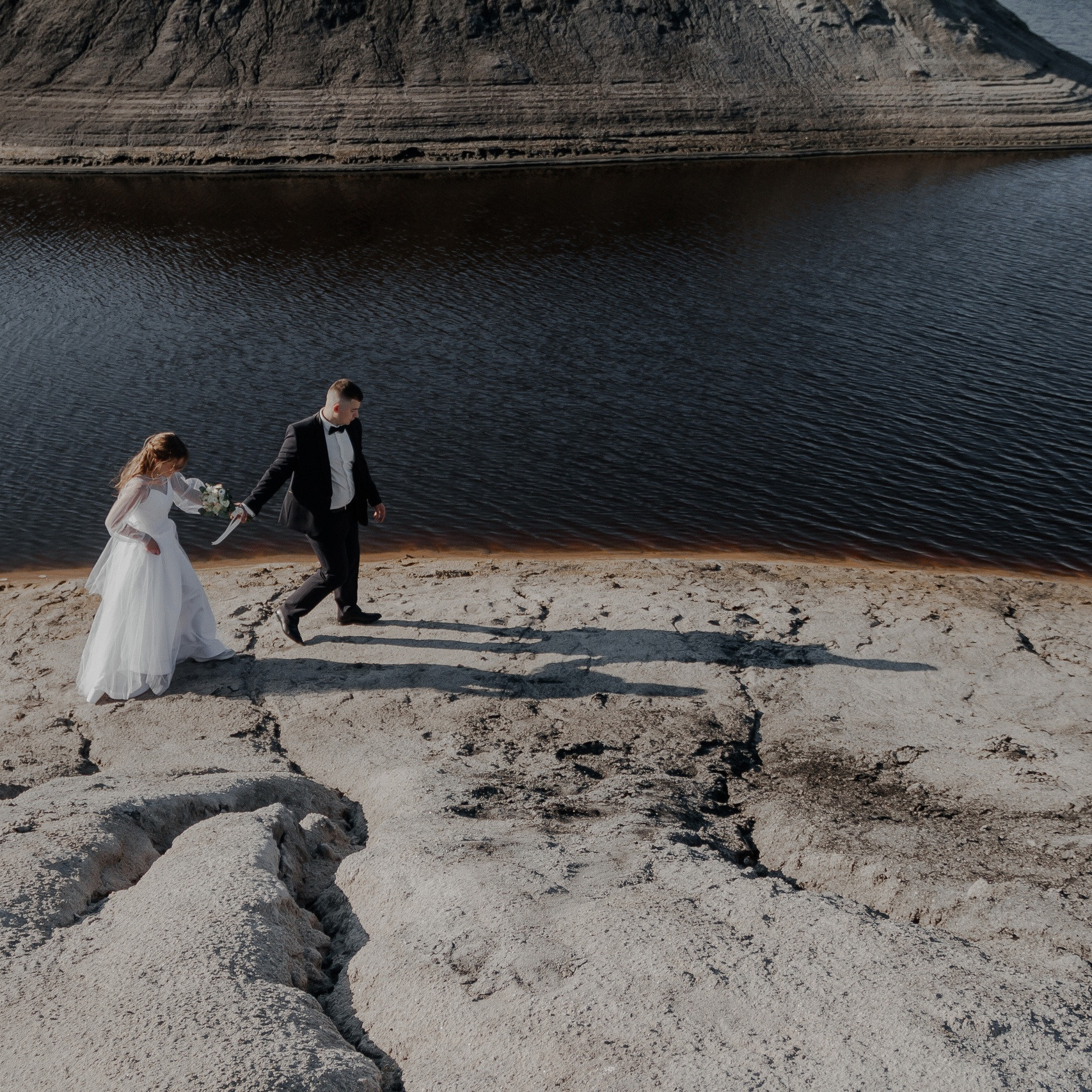 молодожёны идут по набережной их обдувает тёплый ветер 