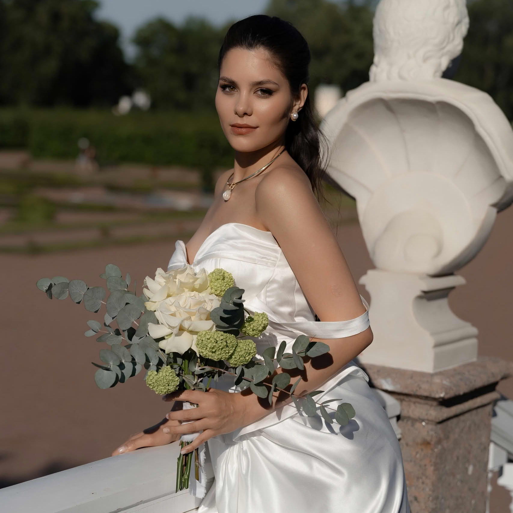 Пара на прогулке в зелёном парке в день свадьбы