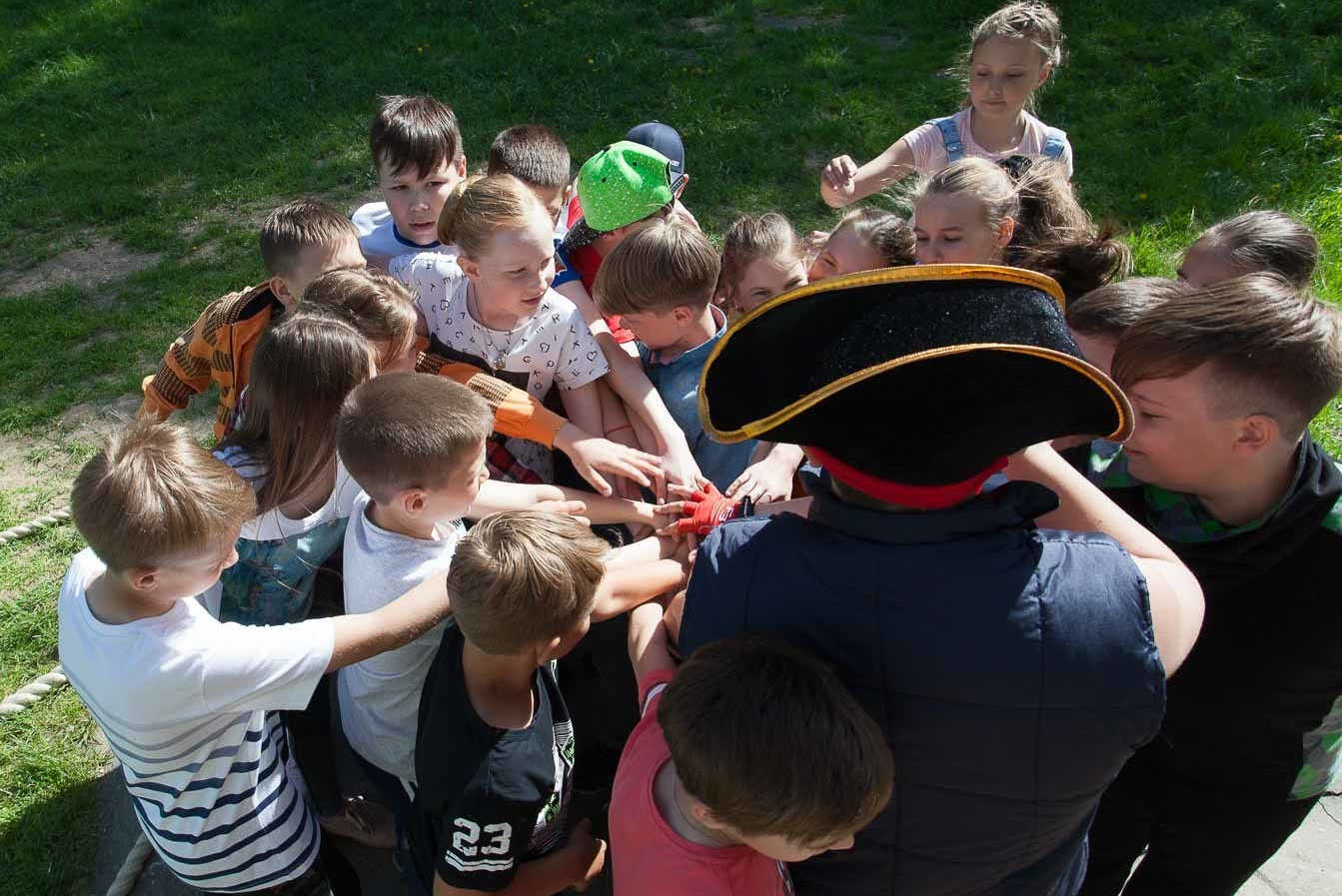 Выпускники 4 класса стоят на улице в плотной группе во время квеста.