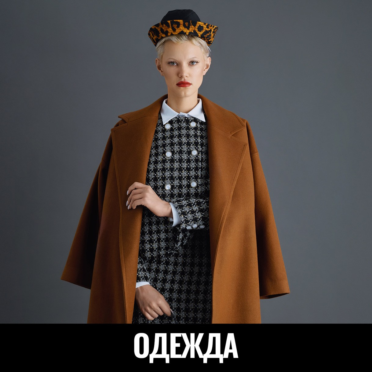 Девушка в коричневом пальто на сером фоне в фотостудии