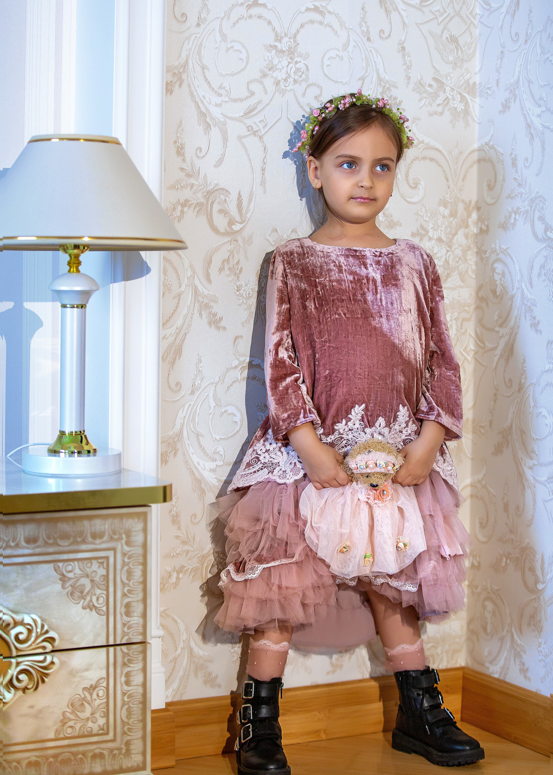 девочка в платье стоит с куклой