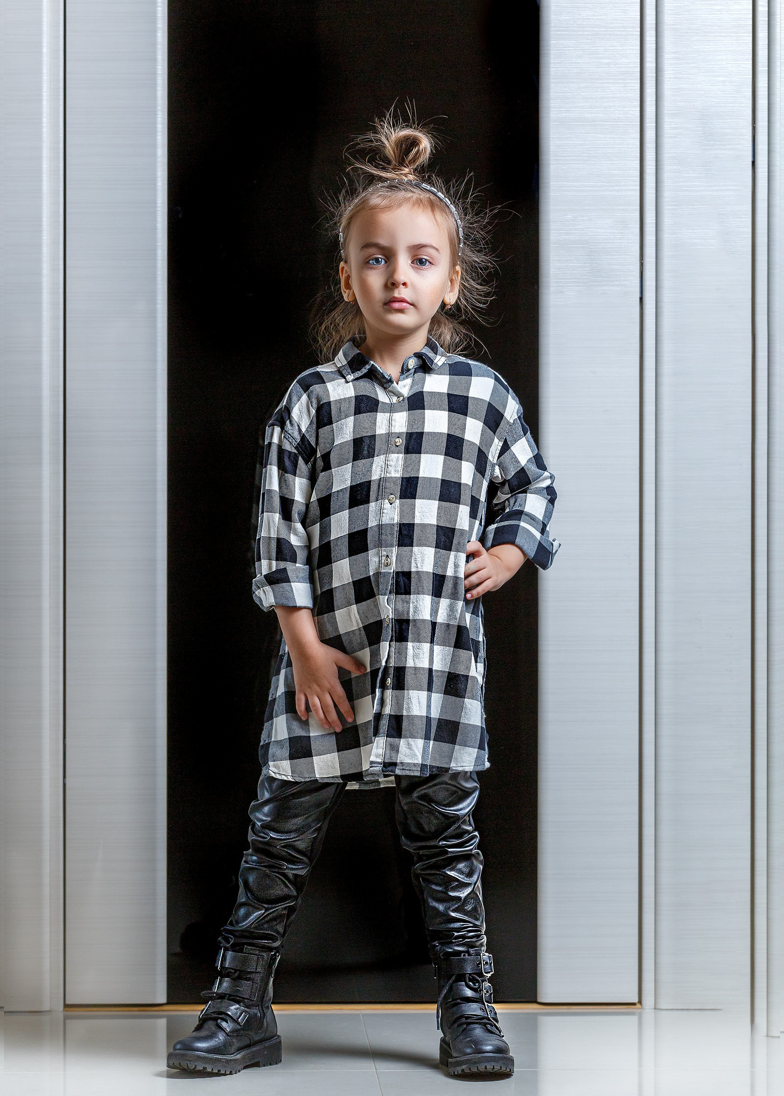 маленькая девочка в клетчатой рубашке на темном фоне