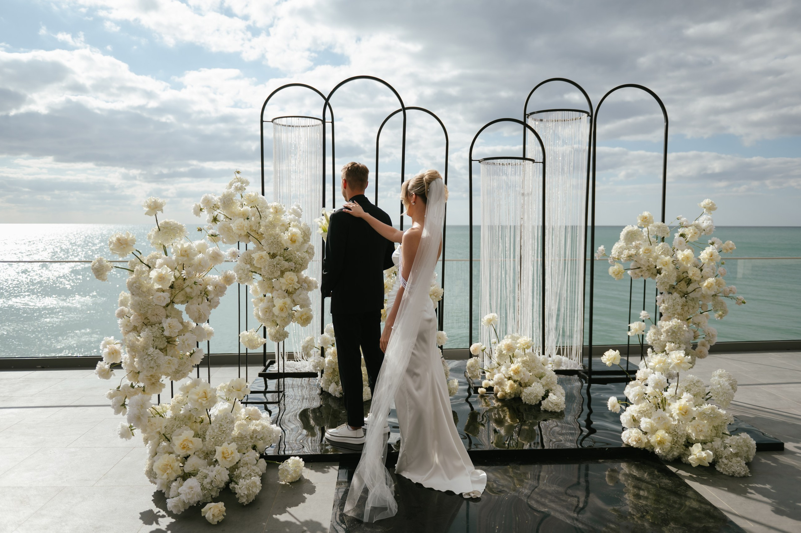 Жених и невеста у алтаря на утренней свадебной церемонии у моря  