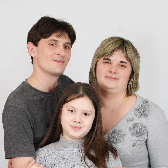 семья мужчина женщина и девочка позируют в фотостудии