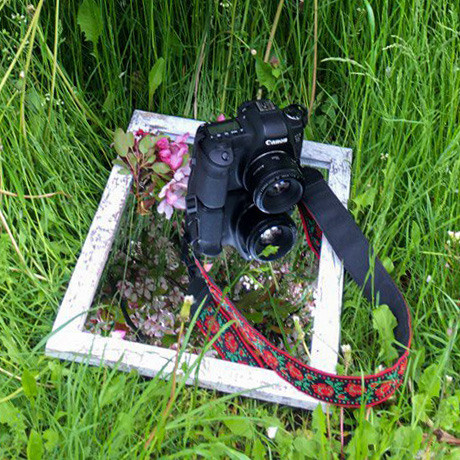 Фотокамера Canon и зеркало на весенней траве