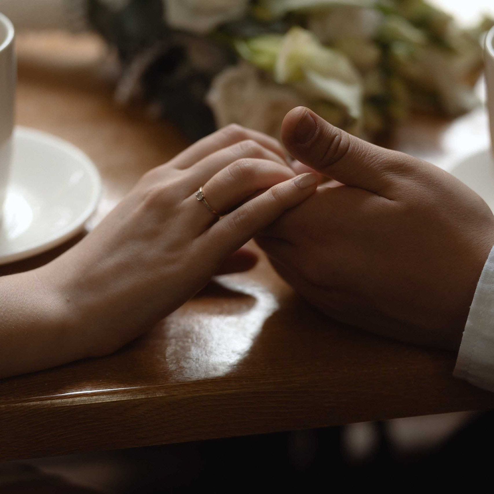 Маленькая свадьба: молодожёны держатся за руки за чашкой чая