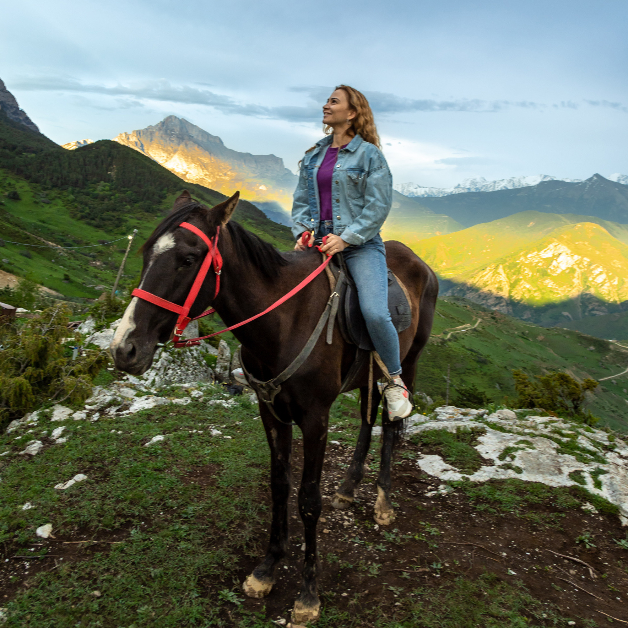 Девушка верхом на лошади на фоне гор в лучах заката, конные прогулки по высокогорным селениям в Осетии, верховая езда по горам