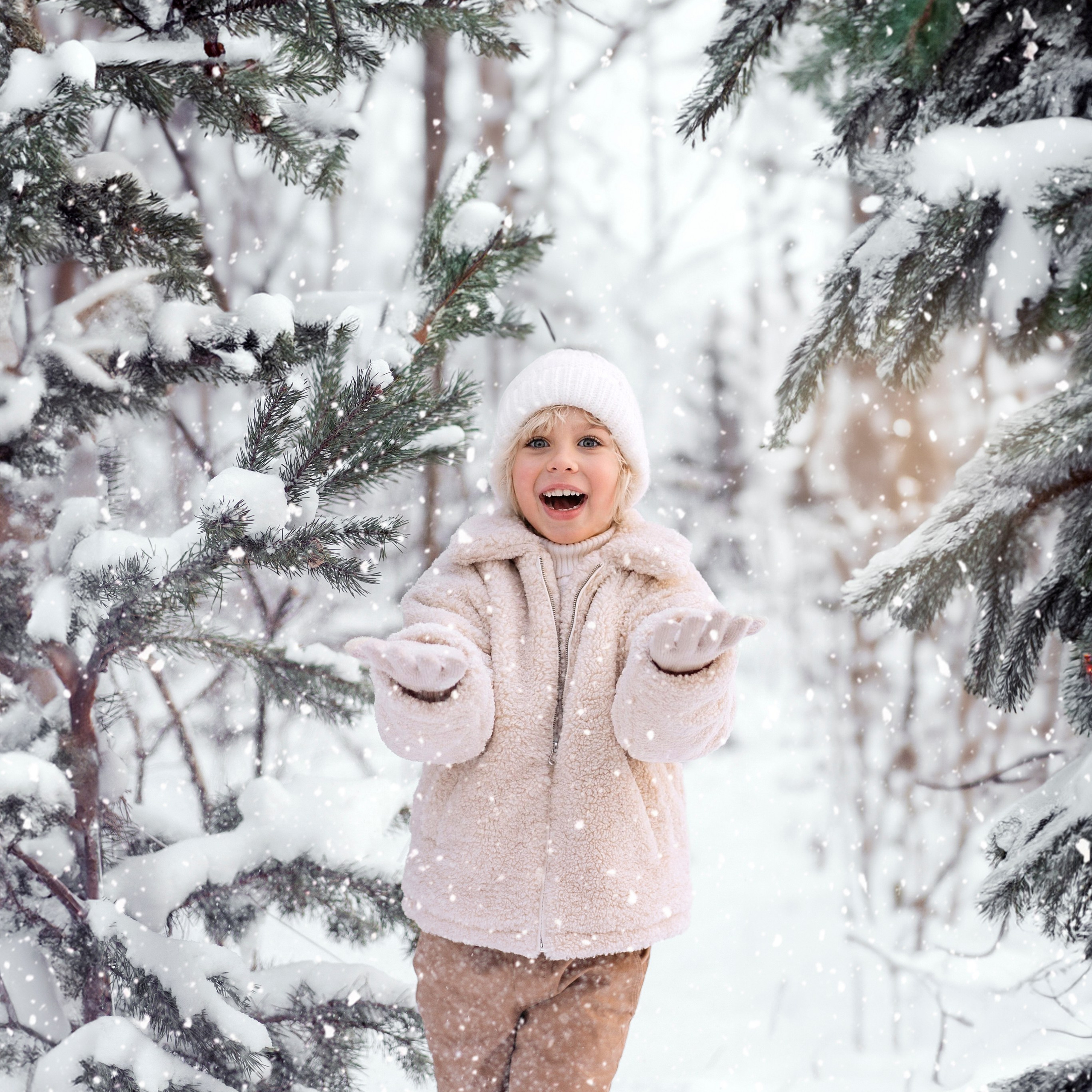 Детская фотосъемка на природе - мальчик играет со снегом в зимнем лесу