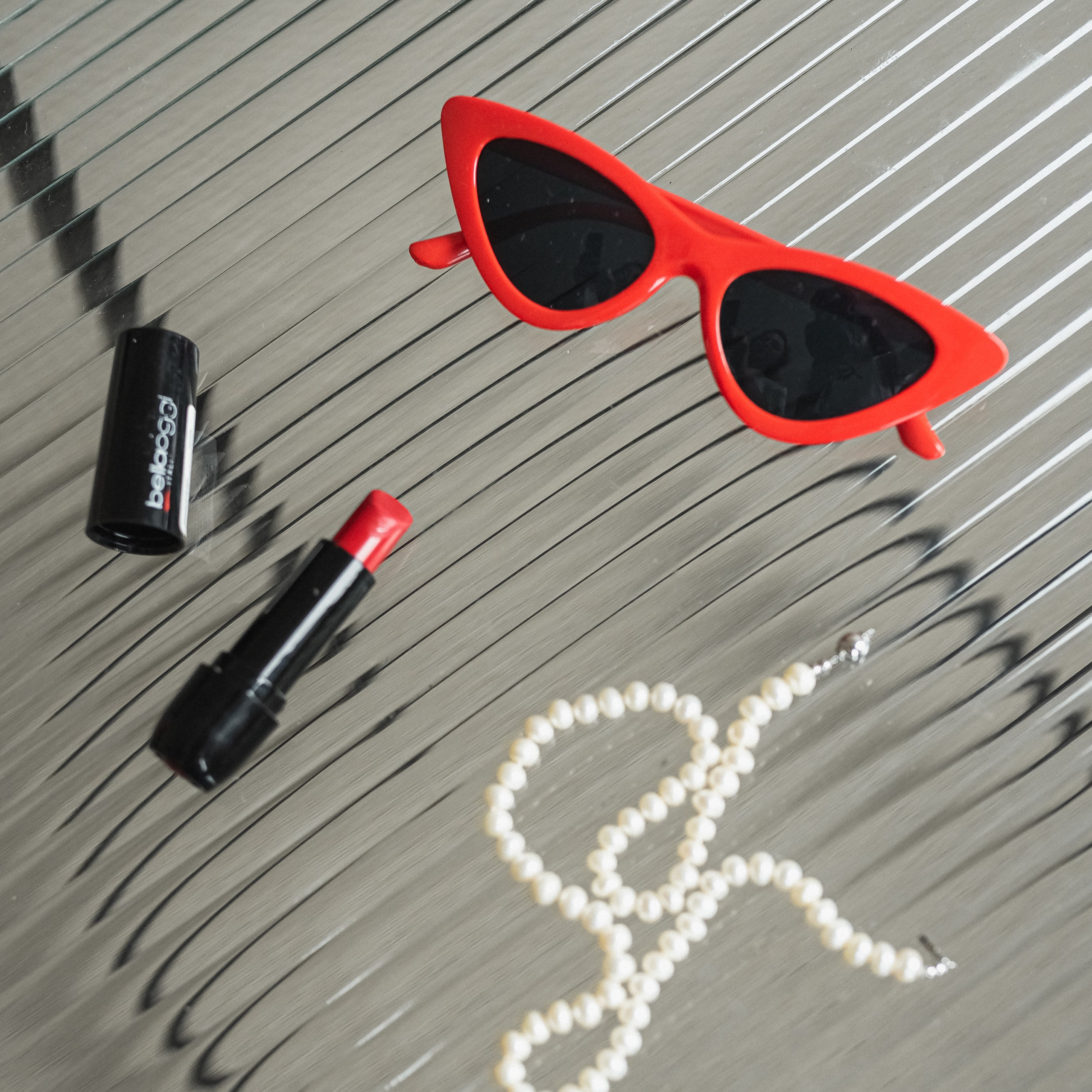 солнечные очки в красной оправе с жемчужной нитью и красной помадой