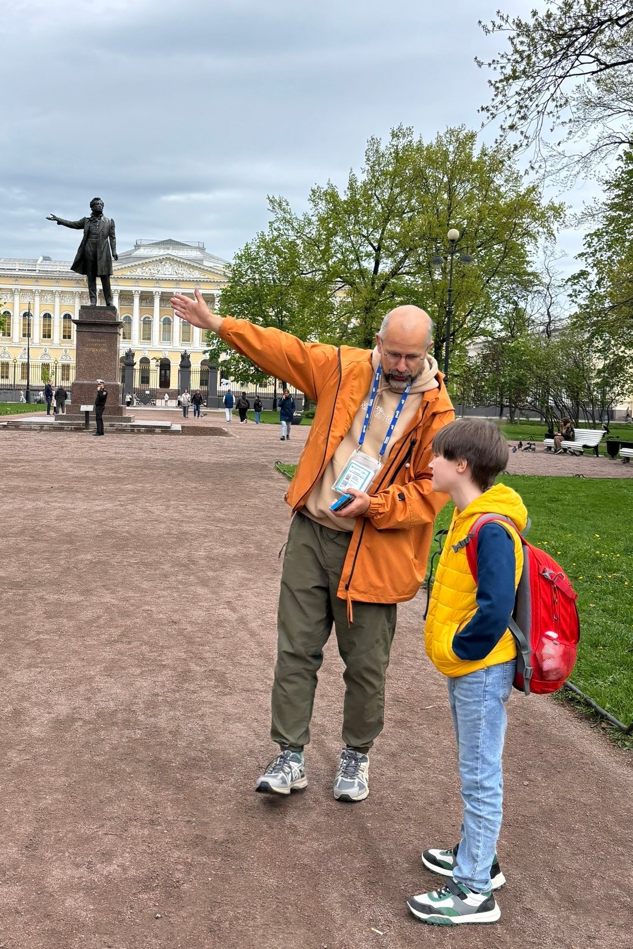 Александр Селезнев, лицензированный экскурсовод, с ребенком у памятника Пушкину в Санкт-Петербурге