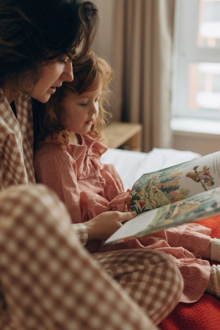 мама читает книжку дочке