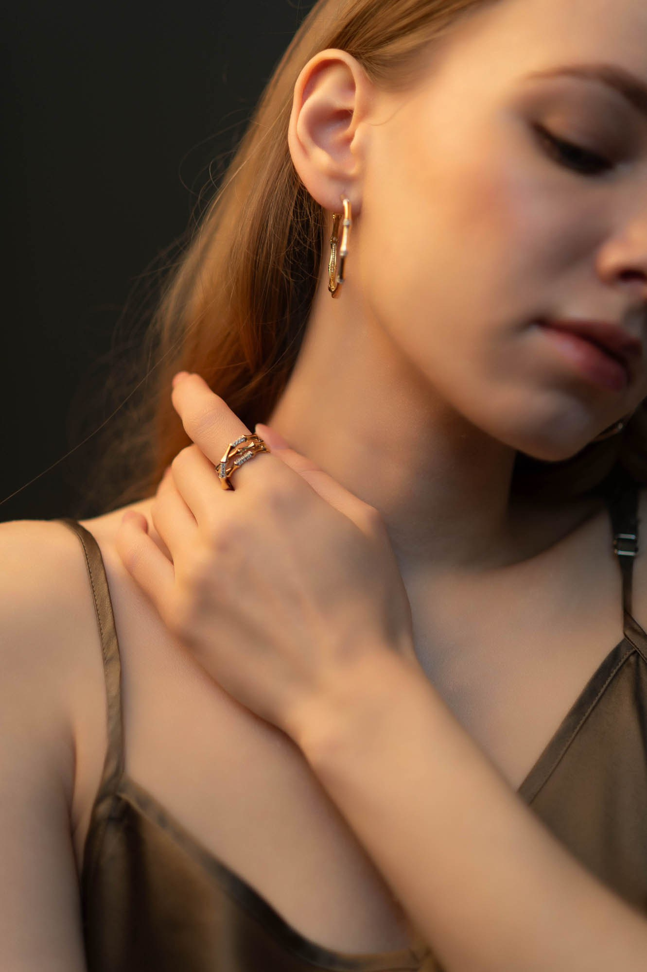 Женщина с длинными волосами закрывает лицо рукой — эмоциональный портрет на выездной фотосессии.