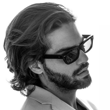 Fashionable bearded man Renan Pacheco wearing sunglasses and a gray blazer, captured in a professional and chic style for lifestyle and fashion segments.