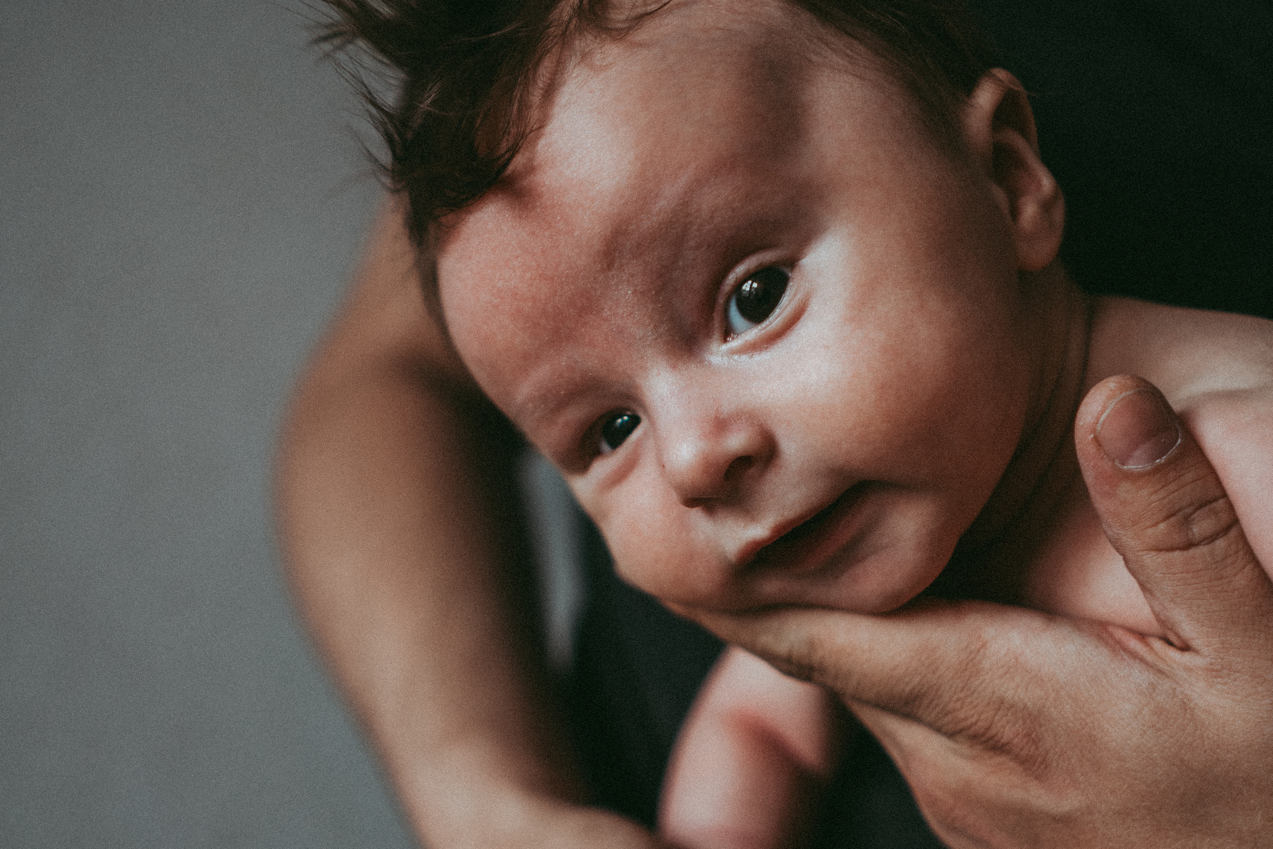 Папа держит новорождённого сына на руках