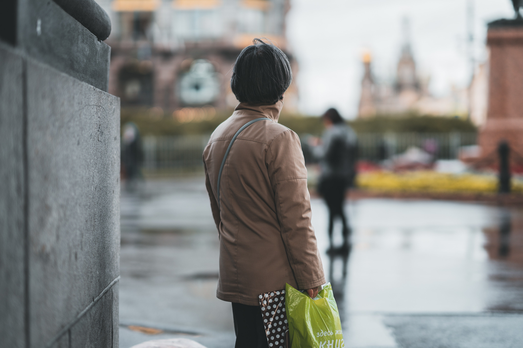 Женщина с пакетом в руках у Казанского собора в Питере