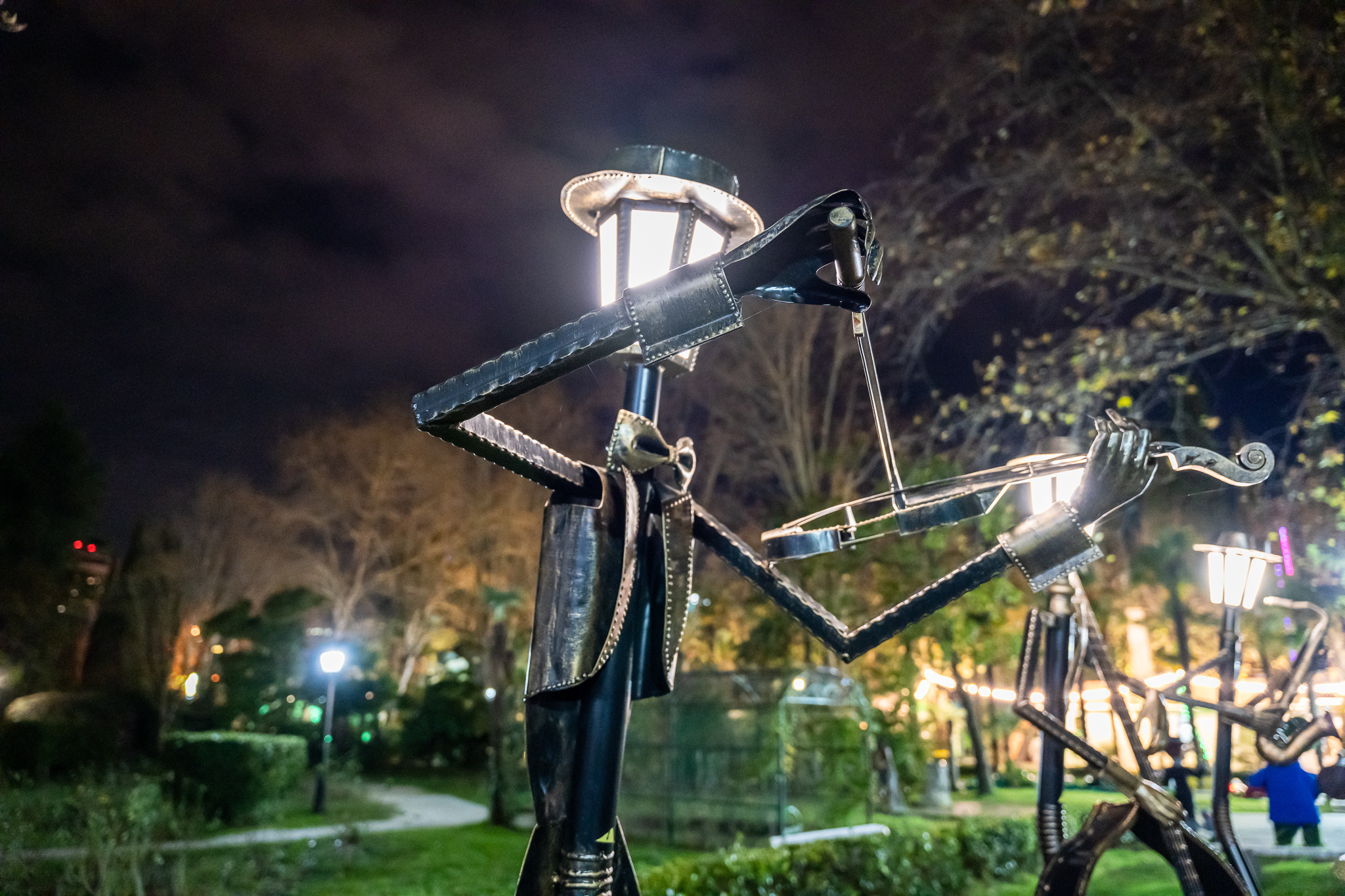 Железная фигура скрипача в парке Ривьера в Сочи ночью с подсветкой