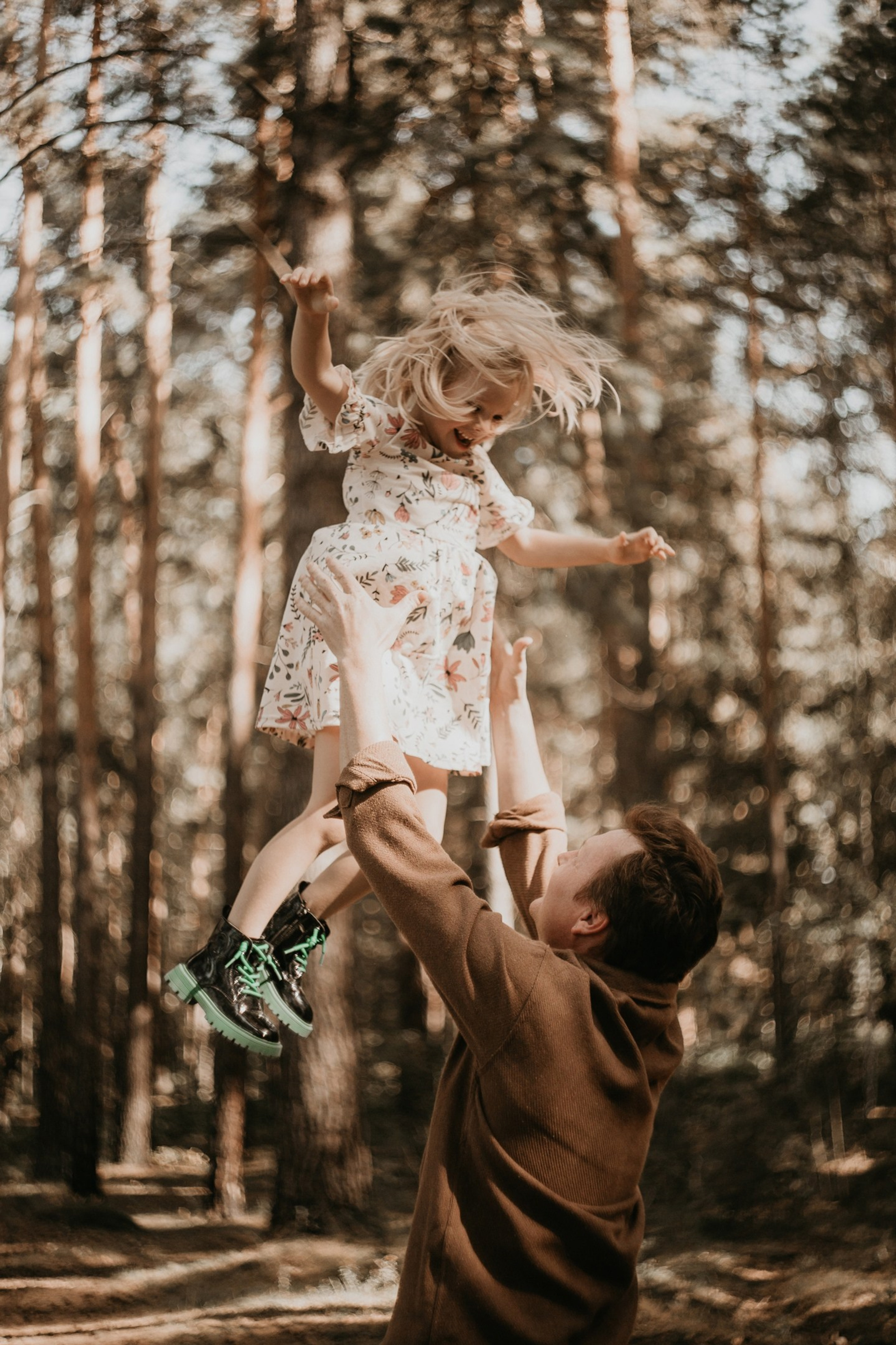 Семейная фотосессия: отец подкидывает дочь на улице