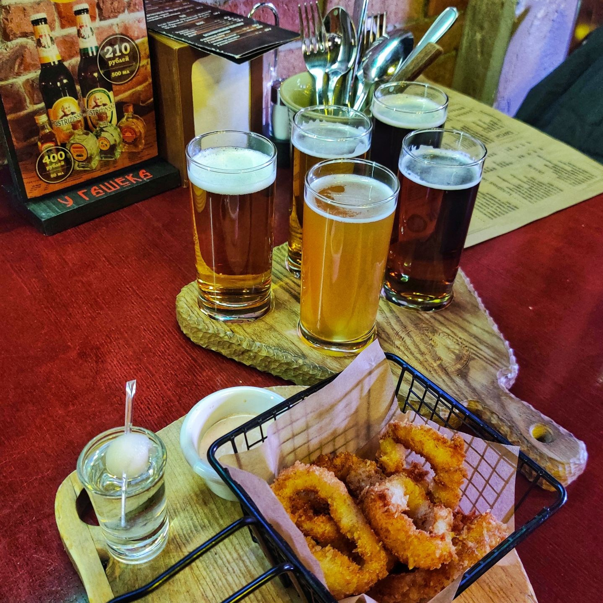 Жареные кольца кальмара и дегустационный сет из четырёх сортов пива на деревянных подносах