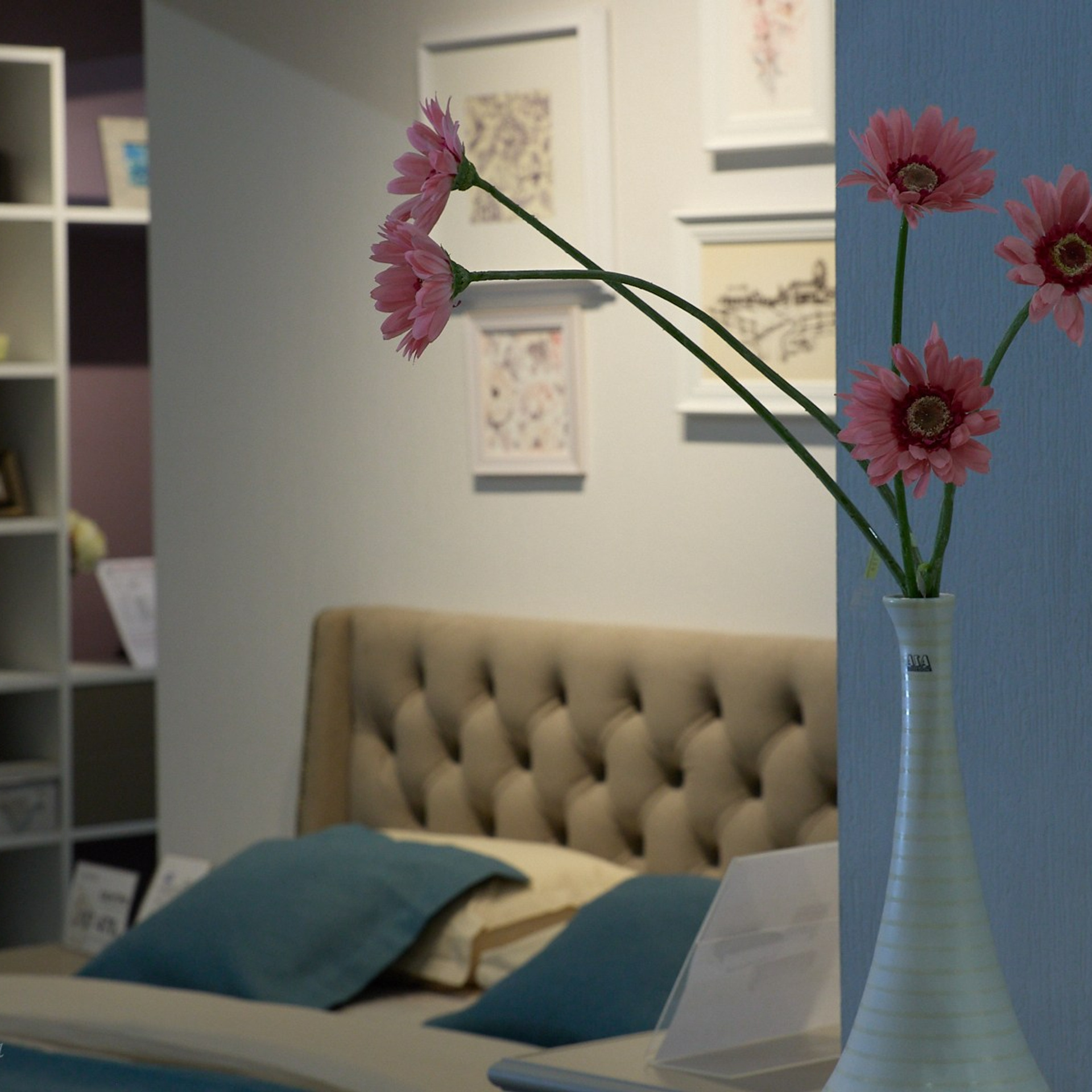 Шкаф, кровать и красные цветы в узкой вазе от интерьерного фотографа в томске.