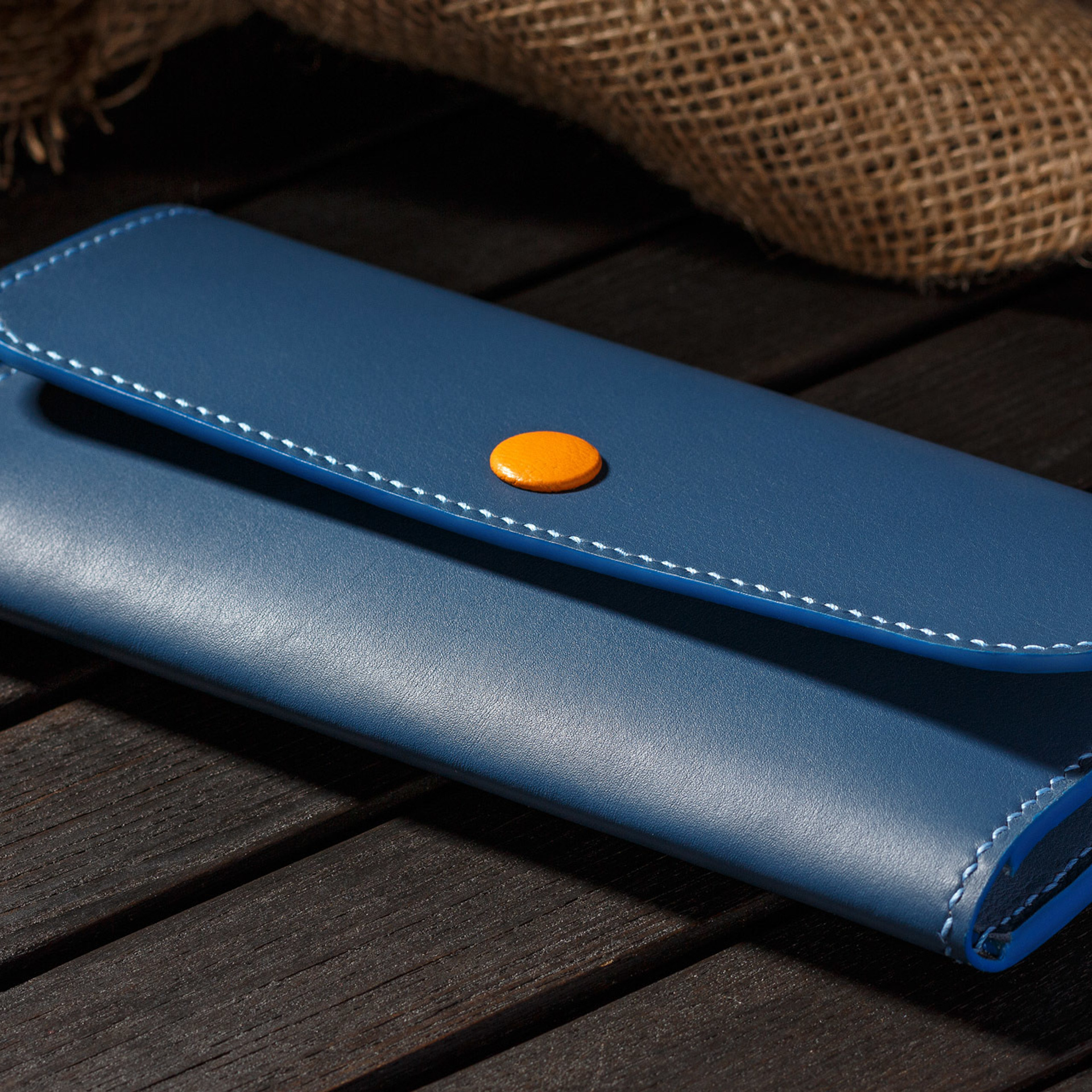 Синее кожаное портмоне на деревянной поверхности