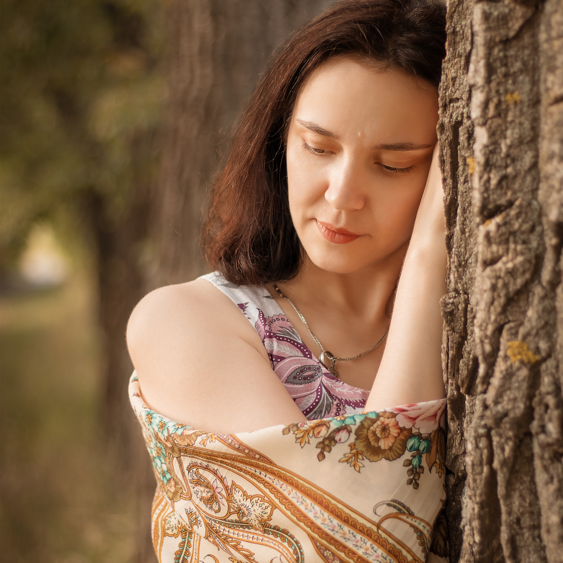 Девушка грустит стоя возле дерева. Крупный портрет девушки осенью в Москве на улице Архитектора Щусева.