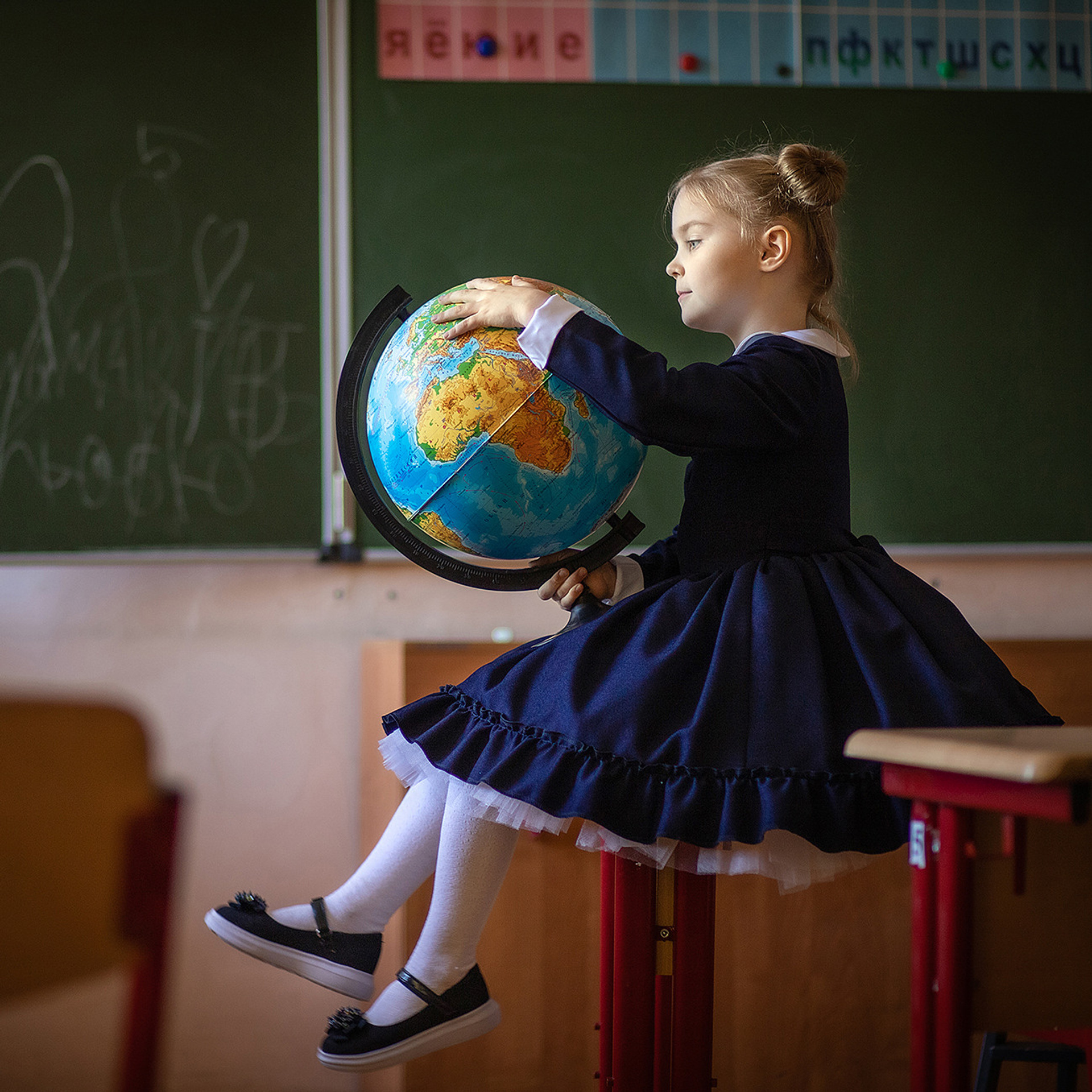 Девочка в школе на фотосессии для выпускного альбома