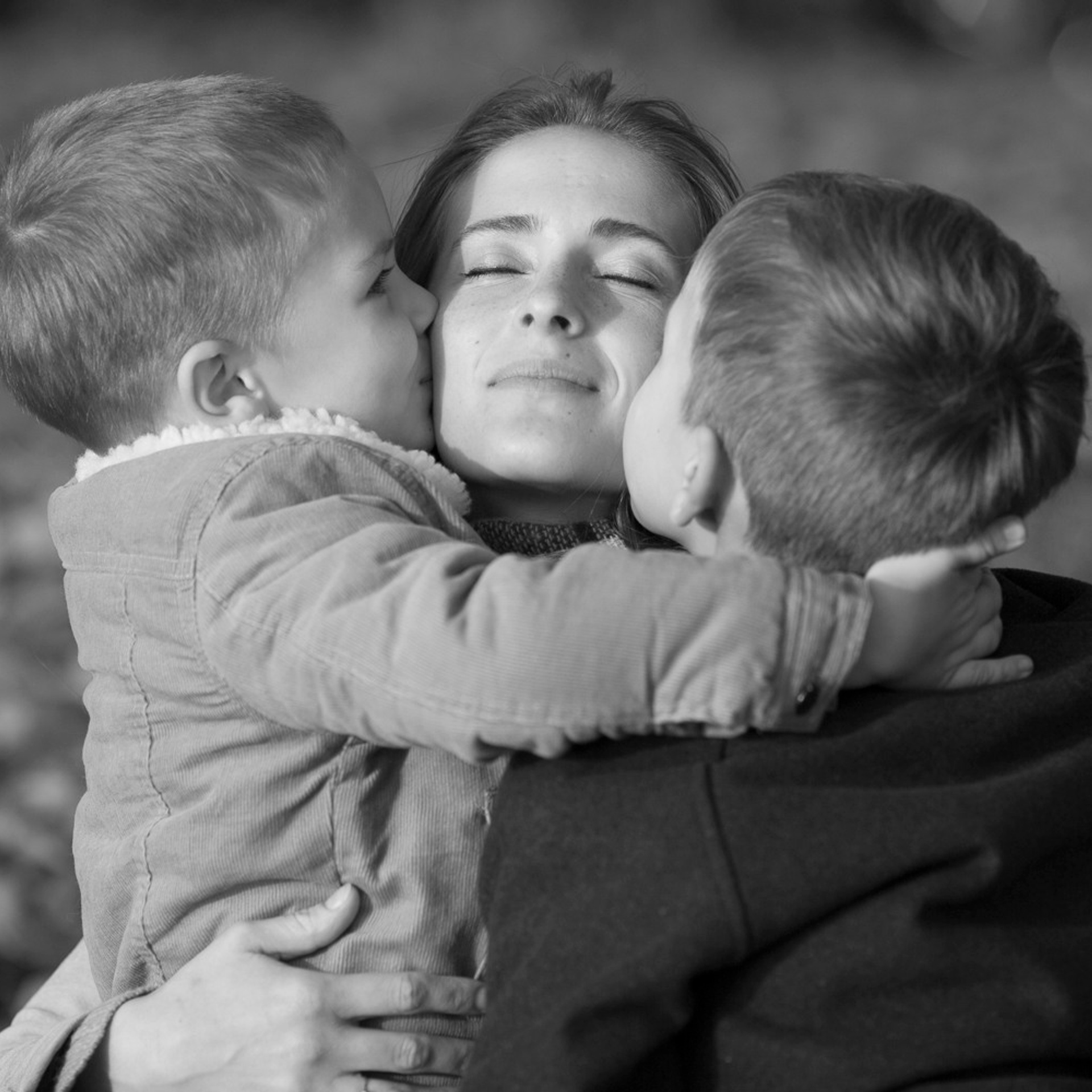 семейная съемка мамы с сыновьями в осеннем парке в золотой час перед закатом в волшебном солнечном свете