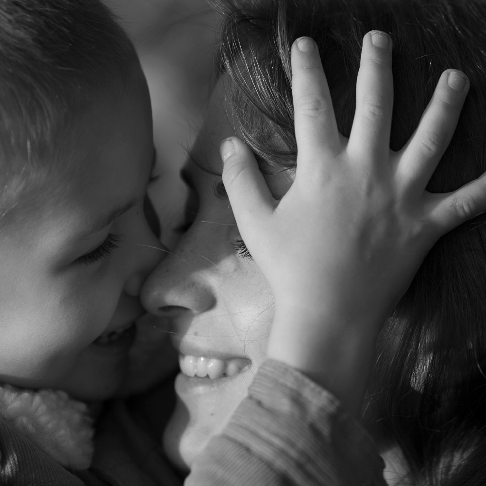 Семейная фотопрогулка мамы с сыном, нежные объятья, мальчик положил свою маленькую руку маме на лицо а его брат кидает листья и она водопадом сыпятся на них
