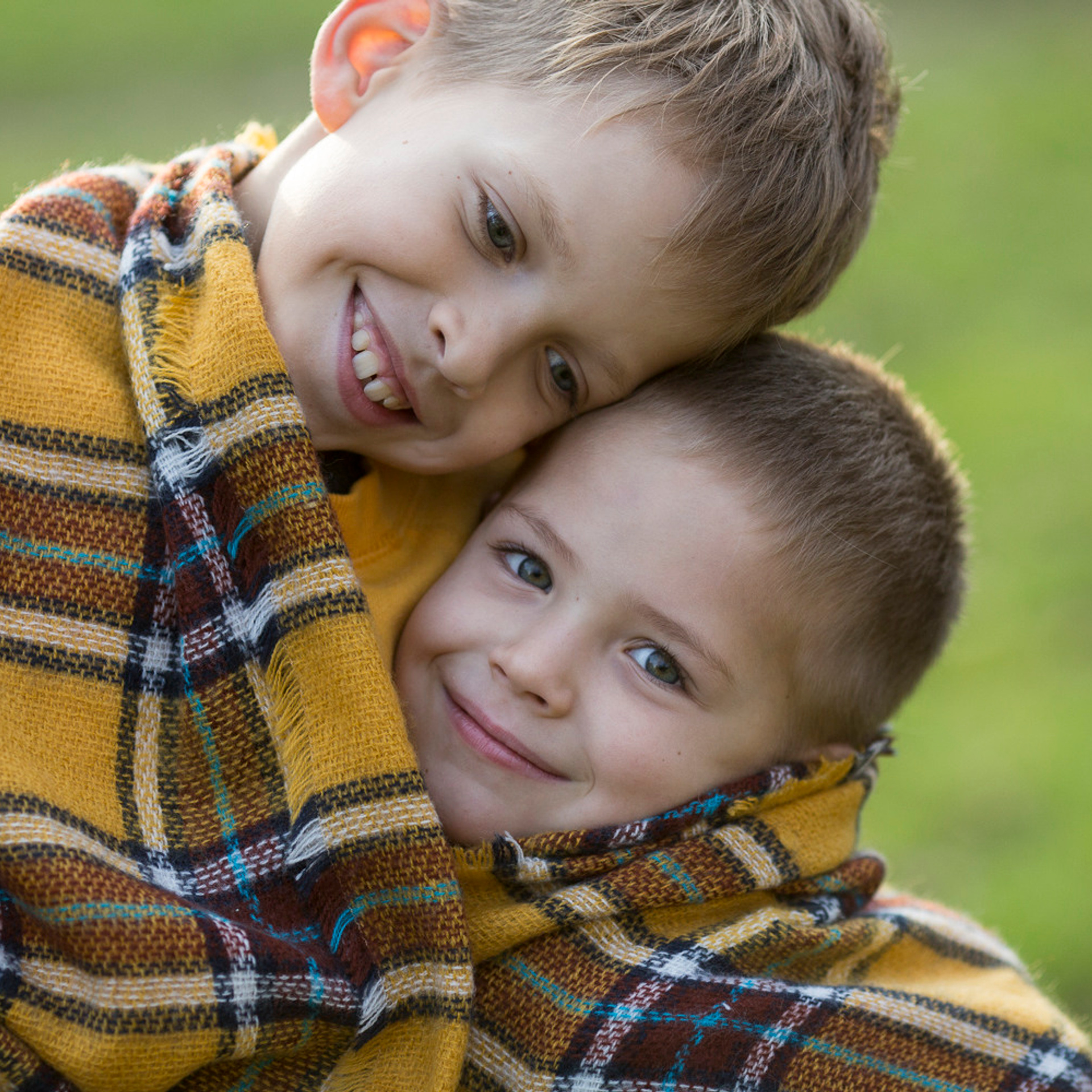 Два брата обнимаются и улыбаются в камеру