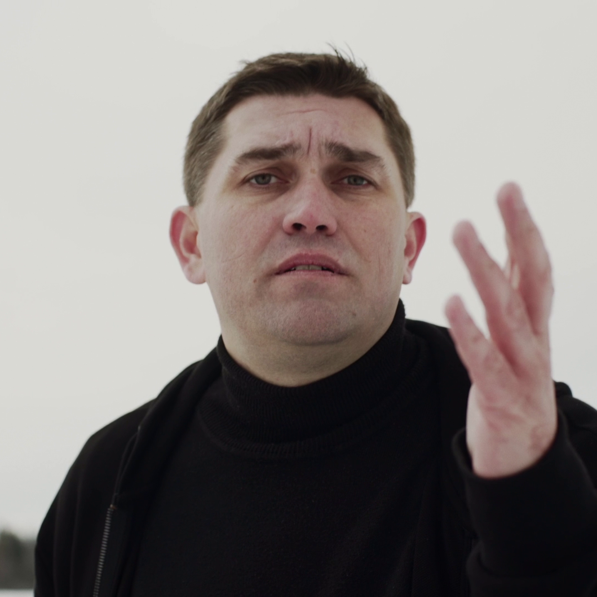 Максим Ерин на фоне неба поет песню