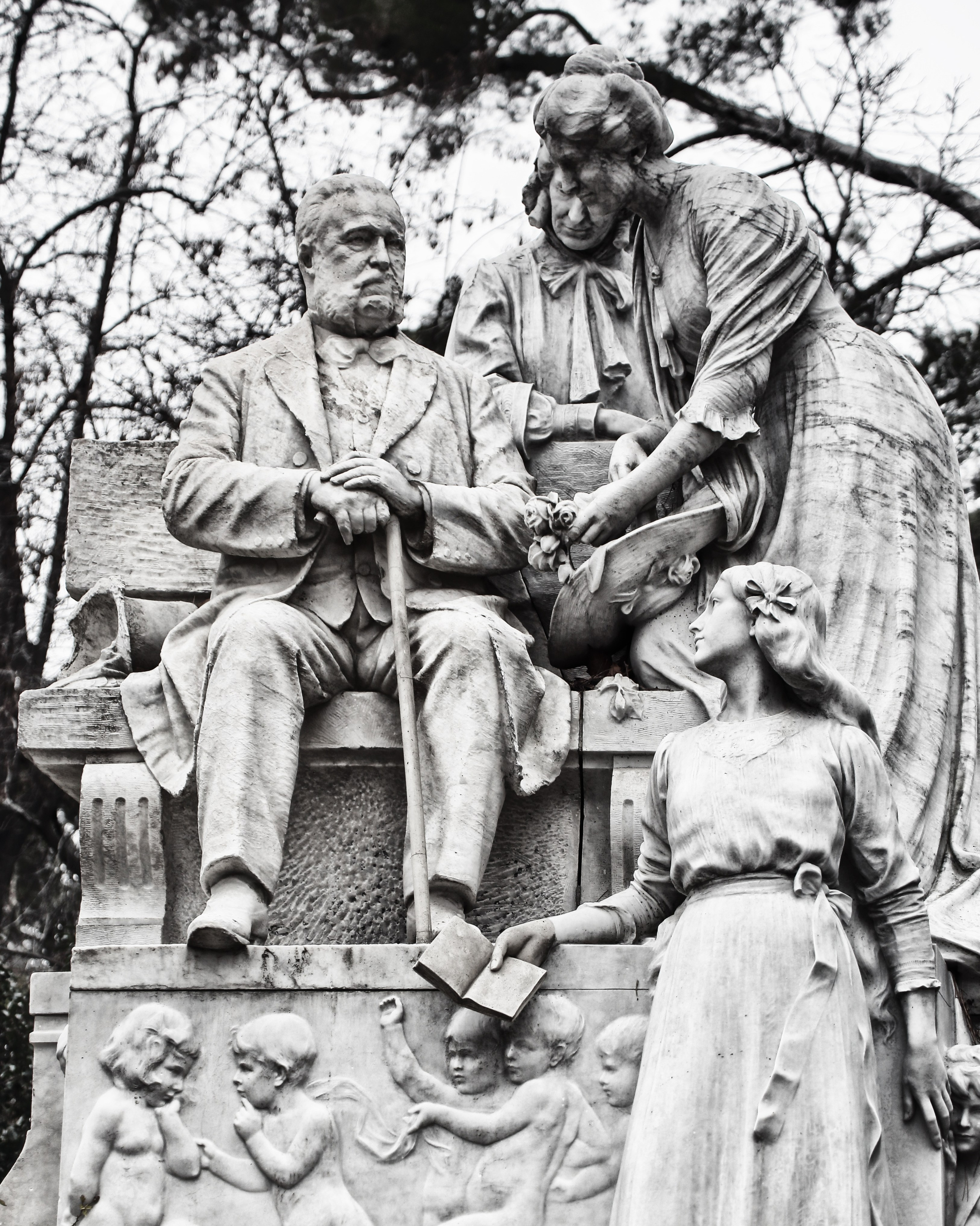 Большой семейный памятник с фигурами мужчины, женщины и детей, детальный барельеф с ангелочками, мемориальная скульптура