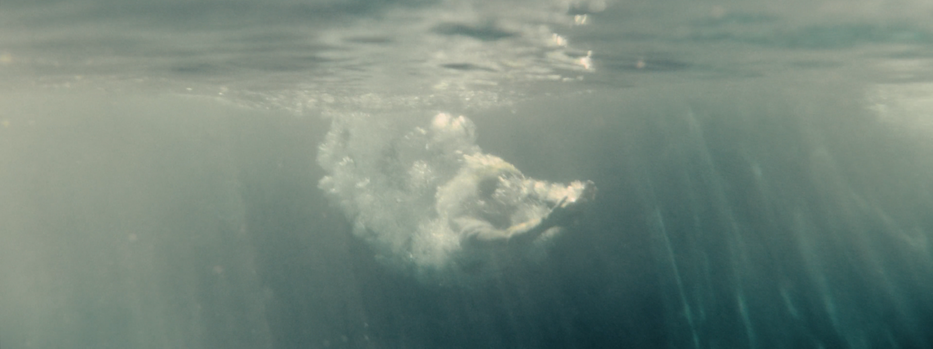 Underwater shot with sun rays breaking through the surface, creating a dreamy and ethereal aesthetic for storytelling fashion films in Los Angeles.