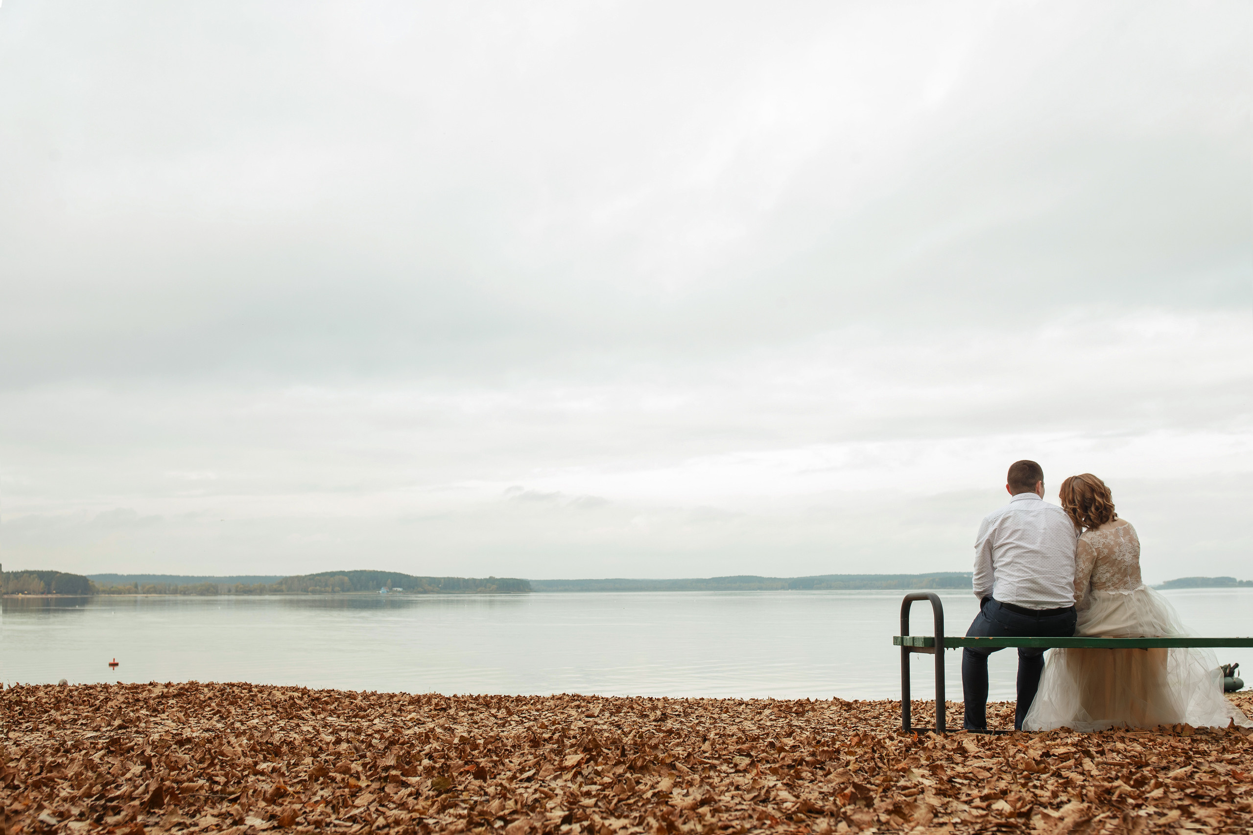 Свадебная прогулка красивой пары на берегу озера