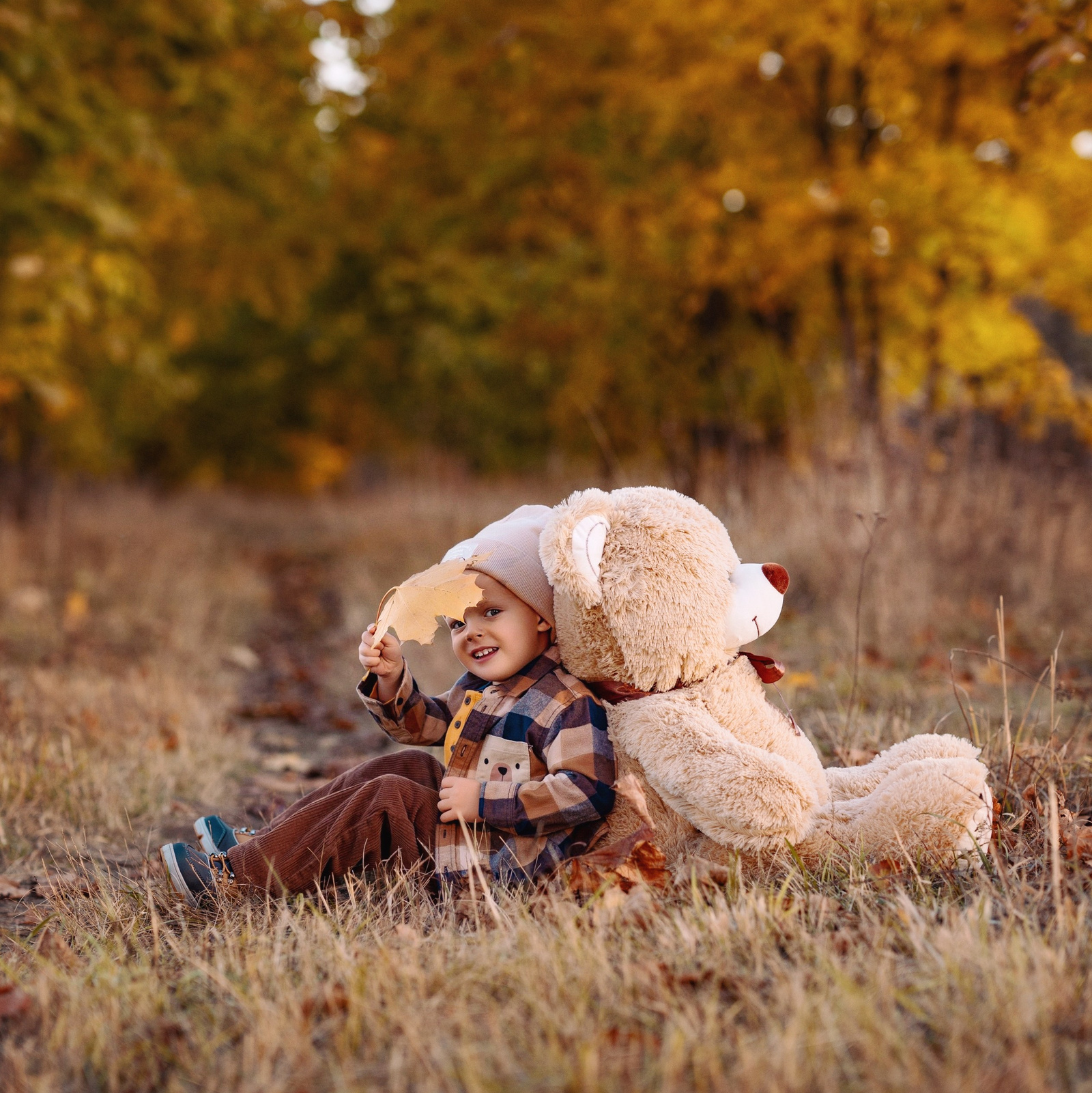 Мальчик в костюме деда мороза на фоне новогодней елки