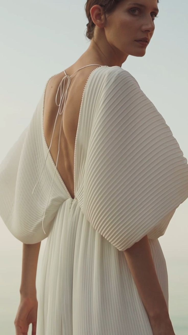 Легкое белое фактурное платье с объемными рукавами и открытым вырезом на спине