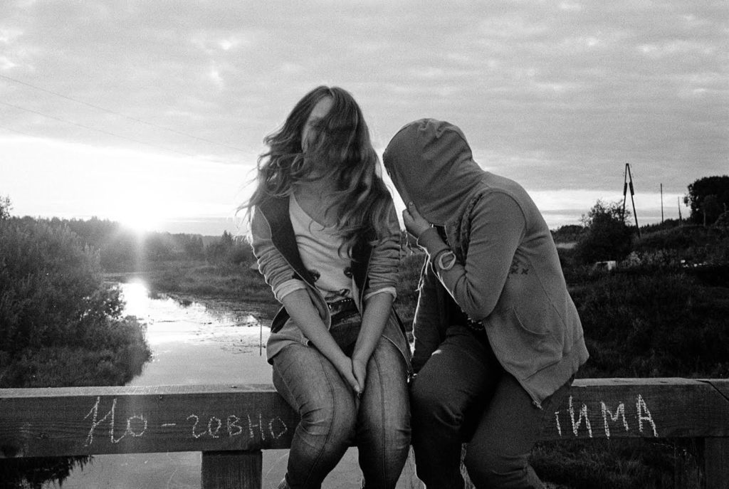 Girls sitting on the bridge across the river Viksenga. Summer 2016.