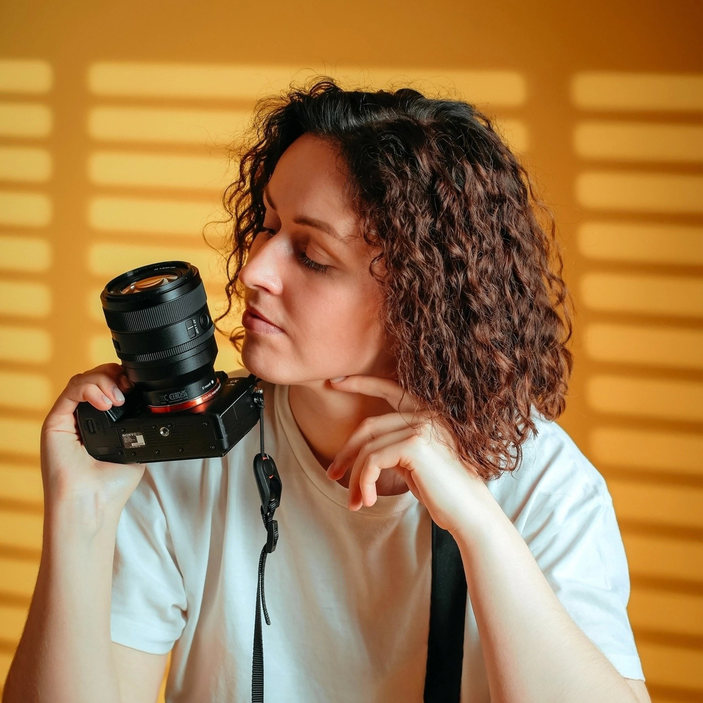 Девушка фотограф с фотоаппаратом, желтый фон