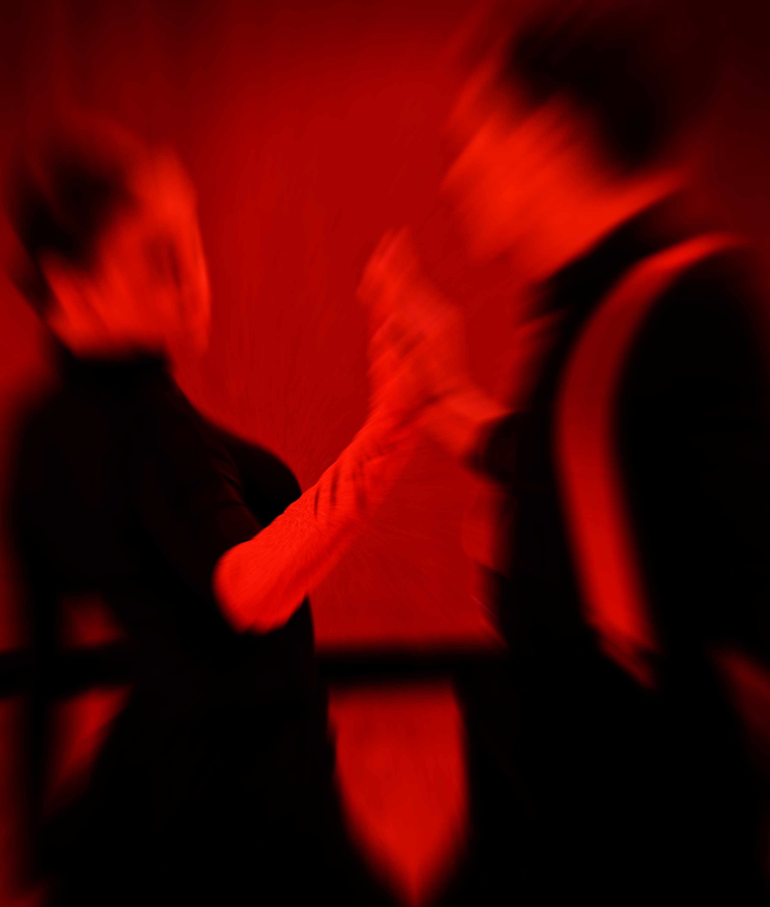 Две размытые фигуры в красном свете, динамичное движение и взаимодействие, художественное размытие, эмоциональная атмосфера