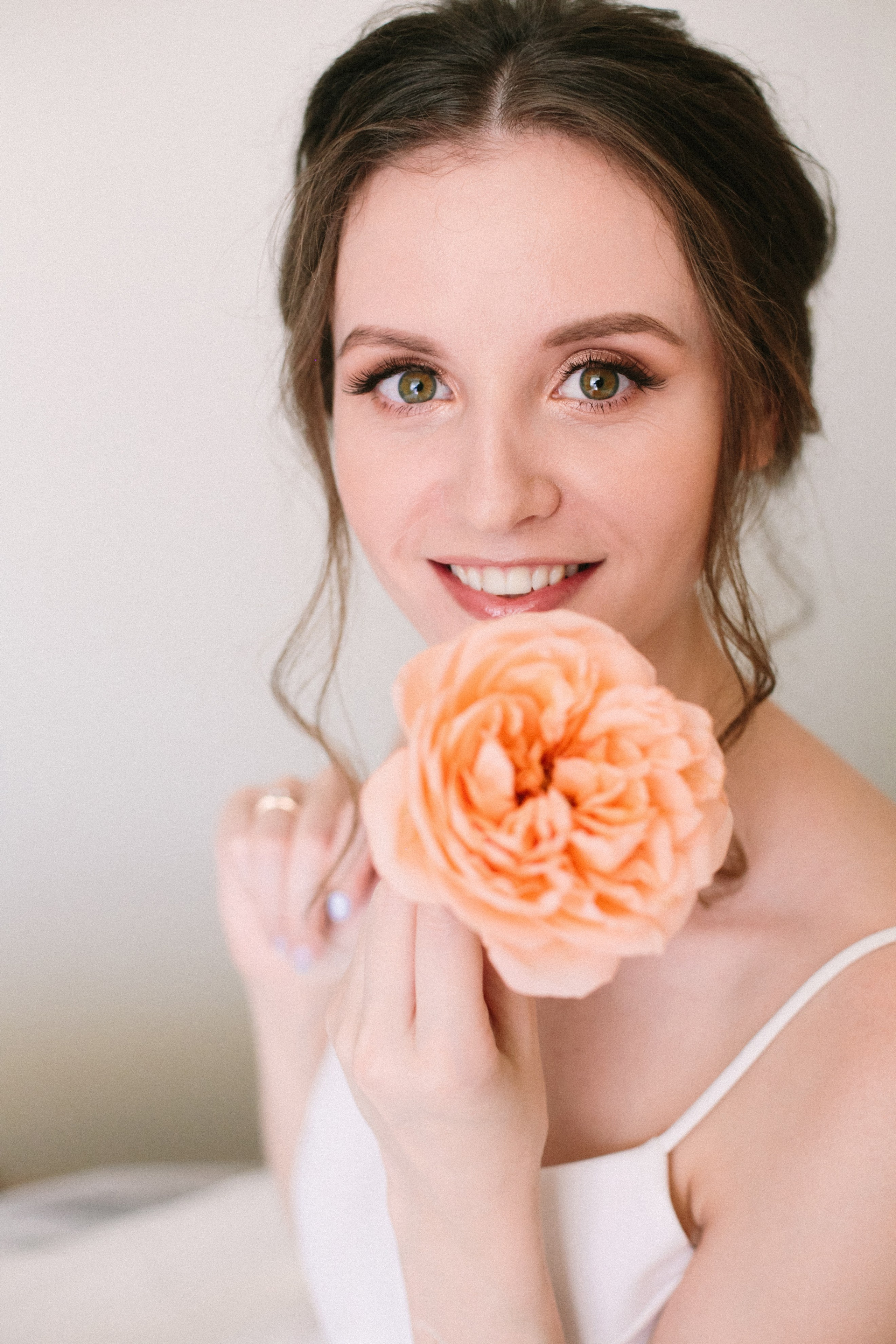 Фотограф ивентов и свадеб, контентная съемка пары в элегантной одежде, невеста в платье с блестящими украшениями и длинными серьгами, жених в черном костюме, они смотрят друг на друга и держатся за руки.