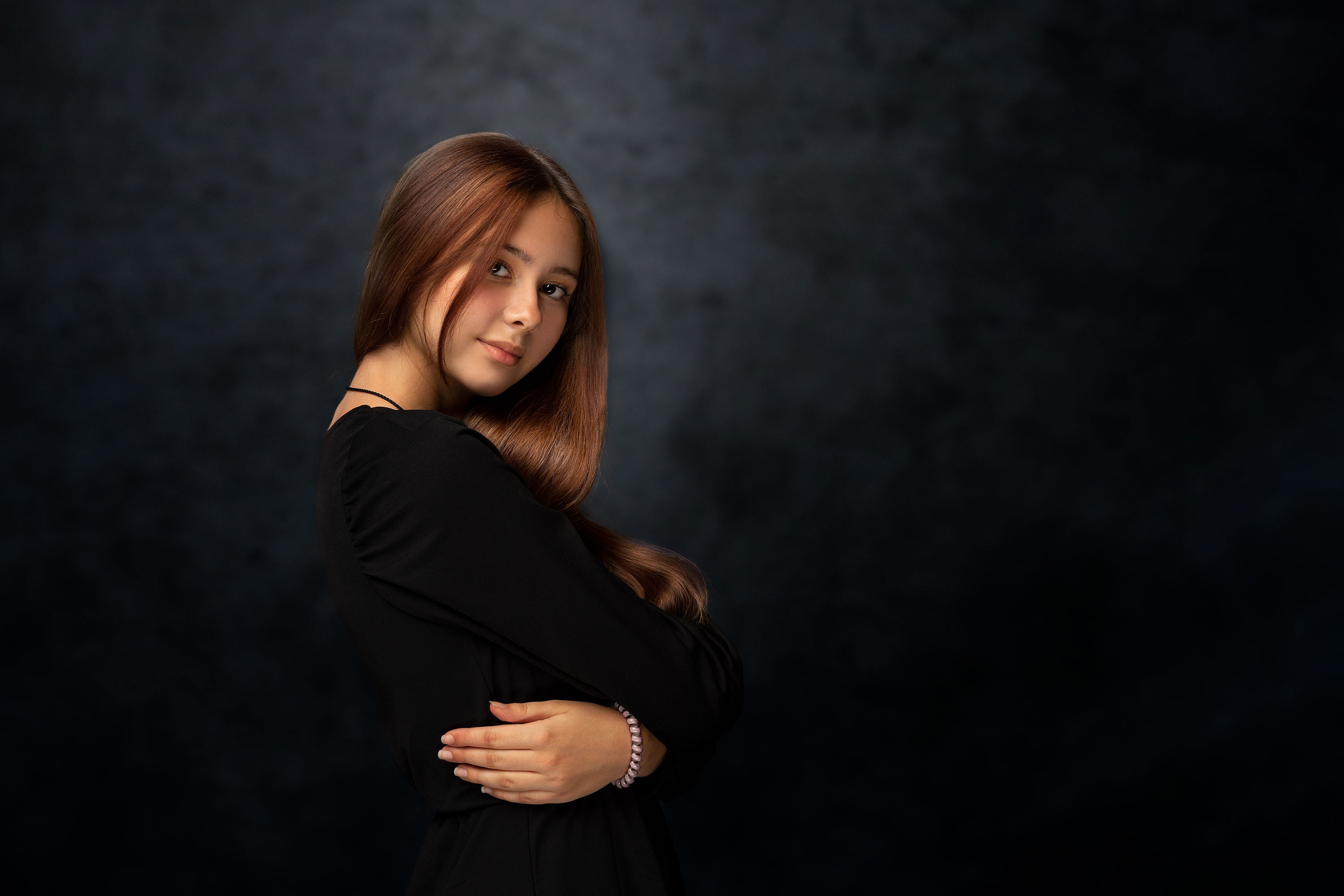 Портрет девушки в студии на тёмно синем фоне.