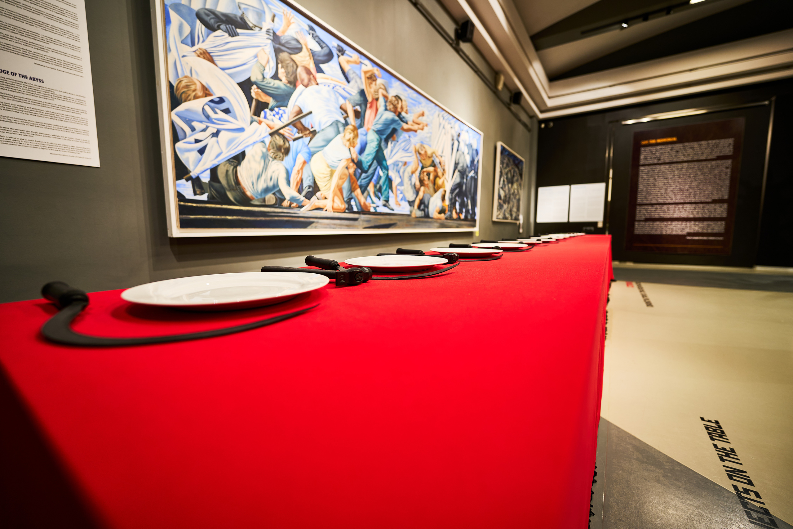 Красный стол с тарелками, серпами и молотками в музее современного искусства Erarta в Санкт-Петербурге